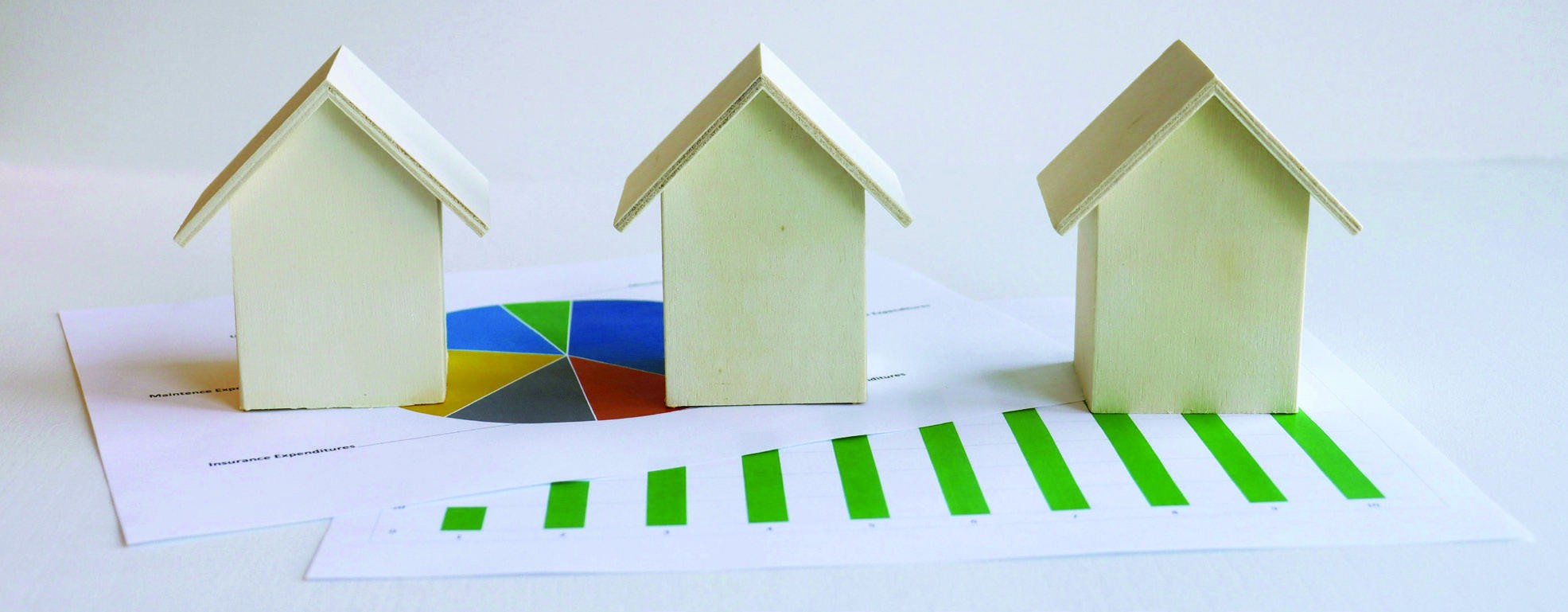 Model houses beside a rising chart