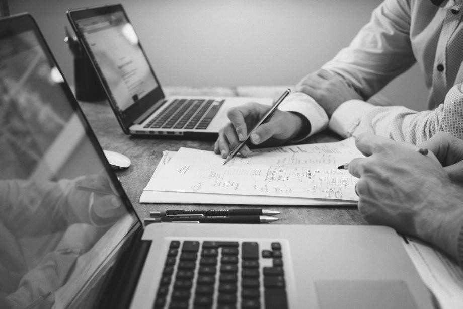 People reviewing financial documents and laptops